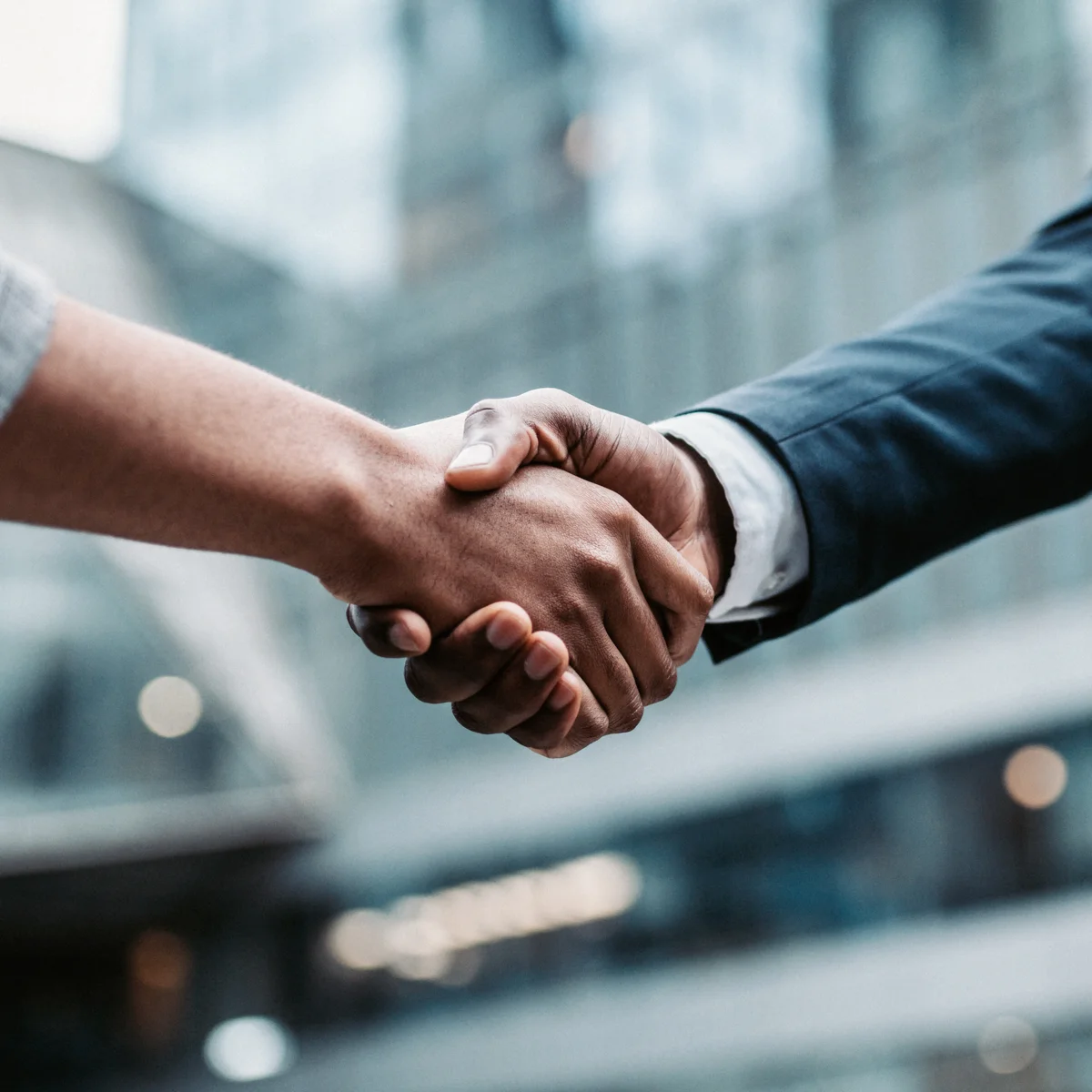 Professional handshake in modern business setting, symbolizing trust and protection of business legacy